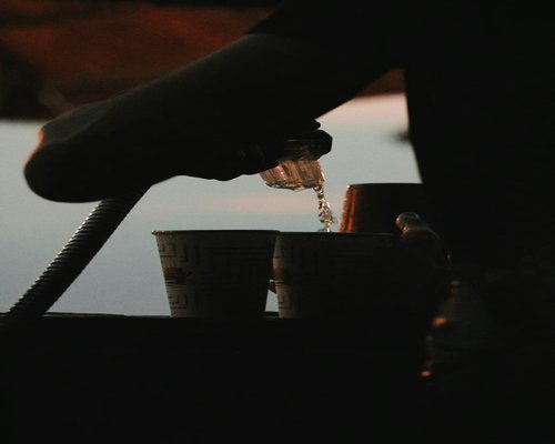 A person pouring coffee in the morning light
