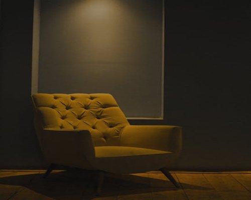 A warmly lit room at night with a comfortable chair